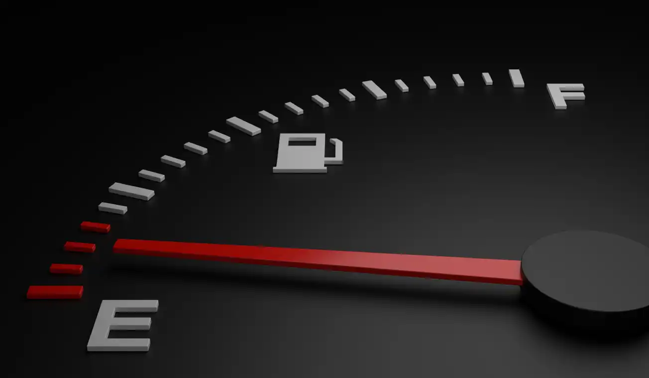 Close-up of a car fuel gauge with the needle pointing to empty, indicating the need for fuel delivery.