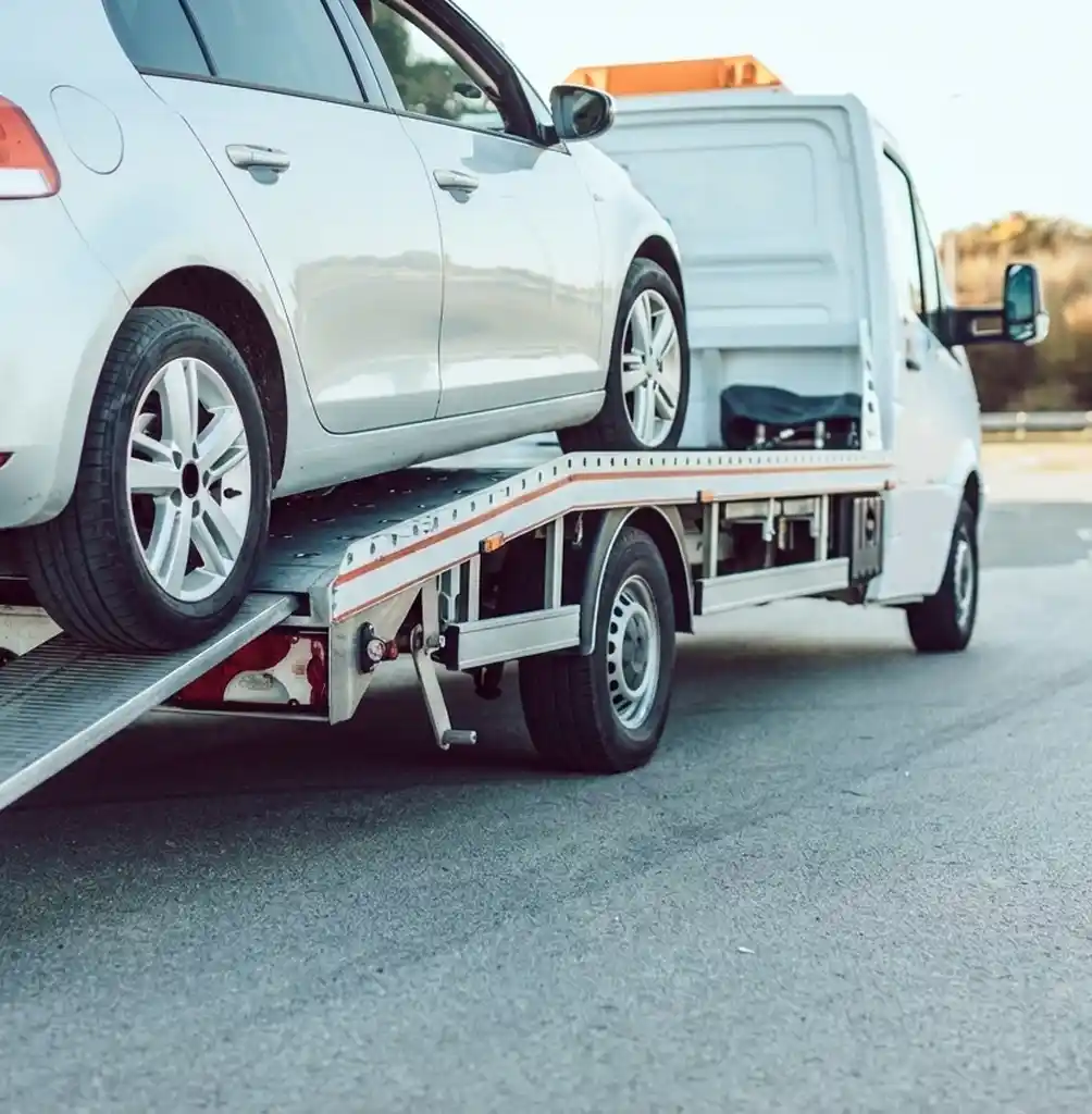 Silver car being loaded onto a flatbed tow truck, highlighting the smooth process of efficient and speedy towing services.